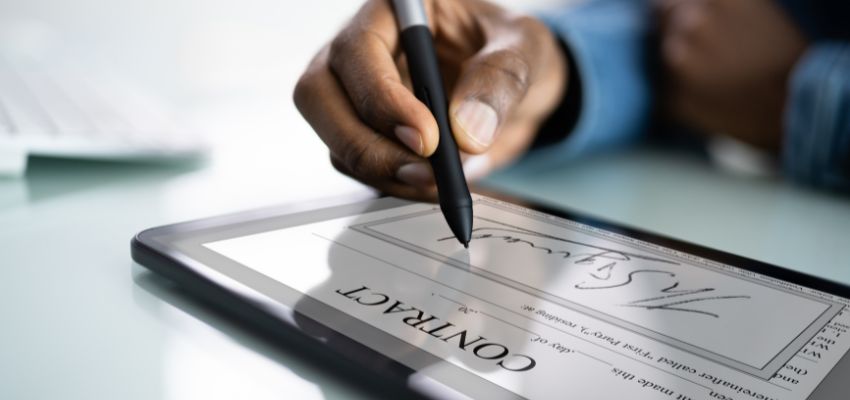 Un empresario firma un contrato digital utilizando una firma electrónica.