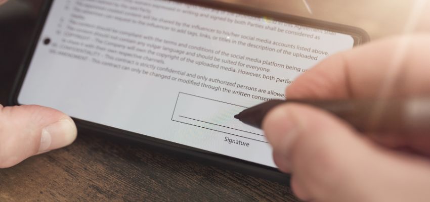 Una persona firma un acuerdo digital utilizando una firma electrónica.