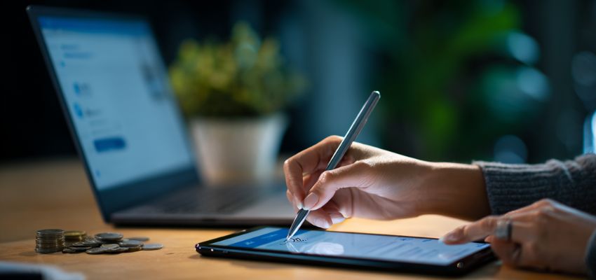 Una empresaria firma un contrato digital utilizando un servicio de herramientas de firma digital.
