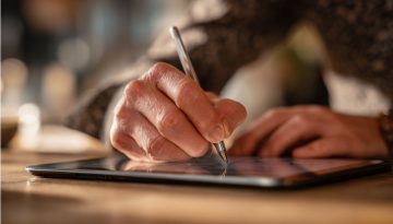 Business professional signing a document on a tablet illustrating duly signed meaning