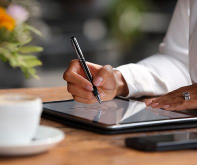 Close-up of a person e-signing a document on a tablet through paperless contract solutions.