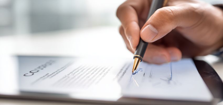 The businessman signed the contract after reading it carefully.
