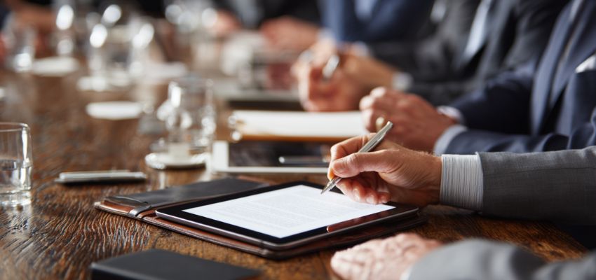 signatories-meaning3 Man signing a digital document on a tablet — demonstrating signatories meaning in electronic or digital contracts.