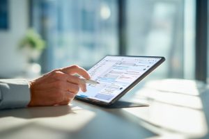 Man using a tablet to manage workflow tasks, showing how contract automation software streamlines document processes.
