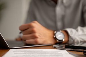 Close-up of professional reviewing paperwork showing types of contract